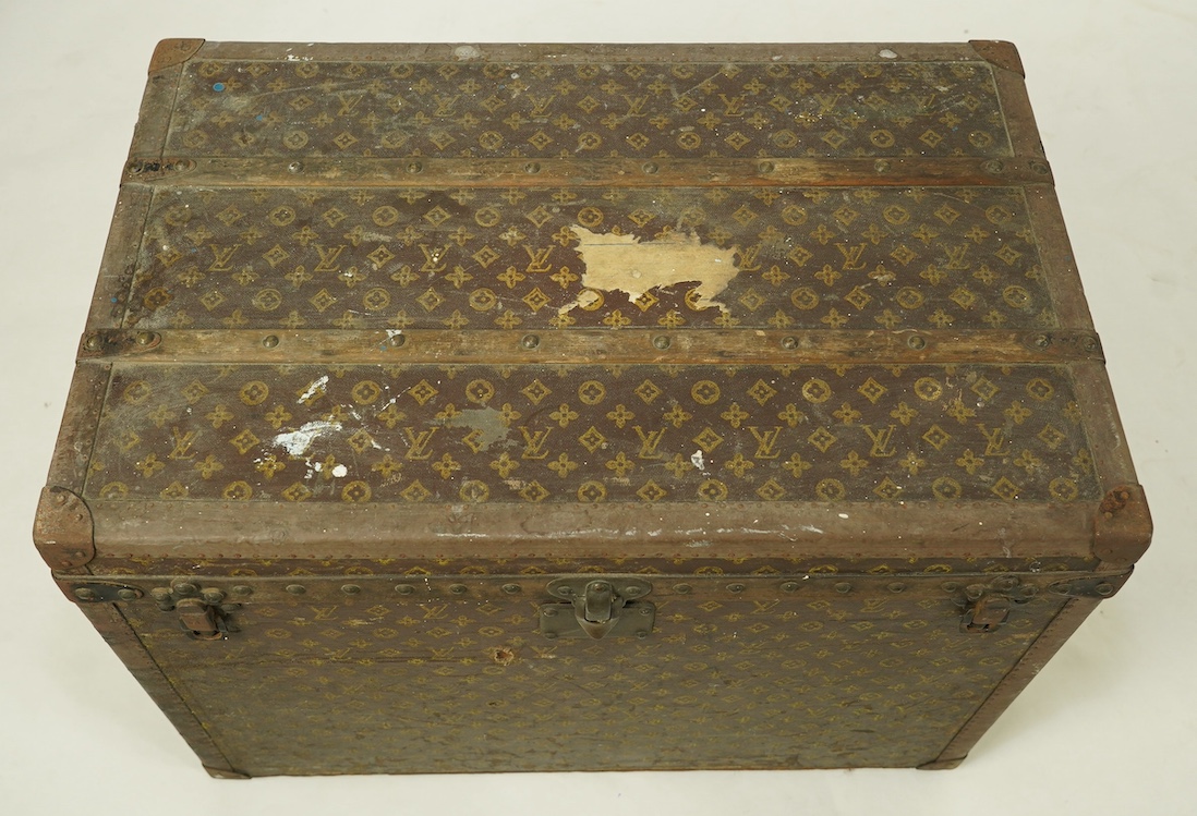 A vintage Louis Vuitton trunk, with black painted iron banding, wooden slats and canvas LV fabric, label for Paris, New Bond Street, Nice and Lille, numbered 776719, the interior with original tray, 76cm wide, 49cm deep,